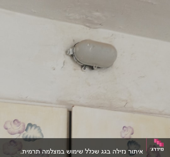 תקרה עם סימני רטיבות ומנורה מותקנת